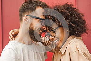 happy young multicultural couple in eyeglasses hugging