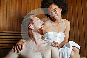 Happy young multiethnic couple enjoying a sauna at a spa resort on wellness weekend