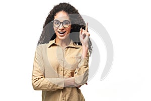 Happy young multiracial curly smiling woman 20s holding index finger up in sign of great solution
