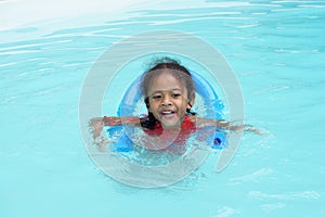 Happy young multiracial girl child learning to swim