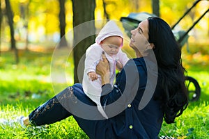 Happy young Mum playing with a cute baby girl.