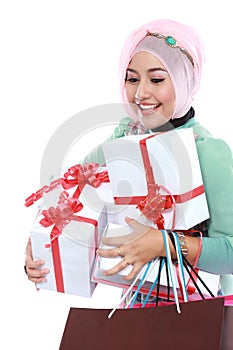 Happy young muslim woman with shopping bag and gift boxes