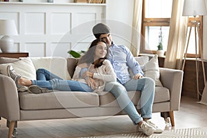 Happy young newlyweds owners of apartment cuddling talking about future