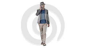 Happy young North African man talking on mobile phone while walking on white background.