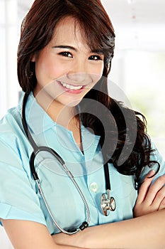 Happy young nurse with arms crossed