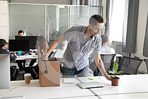 Happy young office worker, intern unpack belongings at workplace