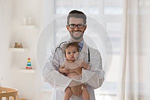 Happy young pediatrician man wearing white coat