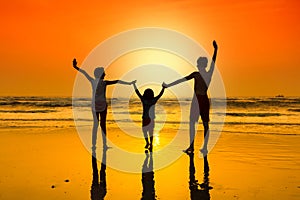 Happy young people dancing at the beach on sunset.