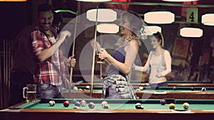 Happy young people enjoying billiard game together