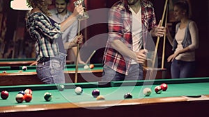 Happy young people enjoying billiard game together