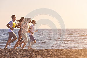 Happy young people group have fun white running and jumping on beach at sunset time