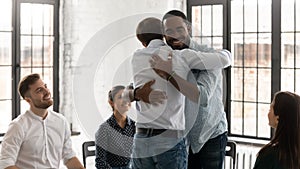 Happy young people hug engaged in group motivation training