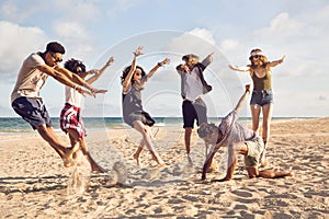 Happy young people jumping on the beach