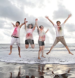 Happy young people jumping in a beach in summer with slow motion and blurry concept