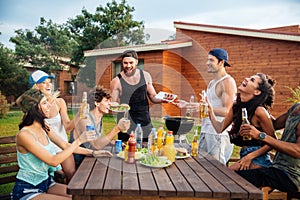 Happy young people laughing and having fun on barbeque party