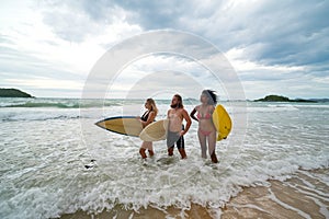 Happy young people with surfboard on the beach.