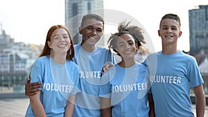 Happy young people volunteer t-shirts posing camera, social teamwork, help