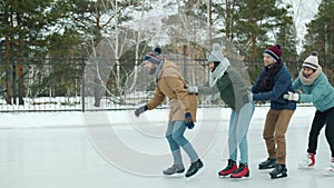 Happy young people in winter clothing ice-skating in park rink laughing enjoying healthy activity