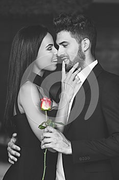 Happy young playful couple with red rose selective coloring