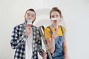 Happy young playful family having fun with each other during apartment redecoration