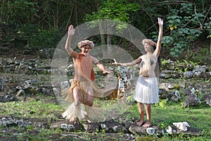 Happy young Polynesian Cook Islander couple dancing in a ancient