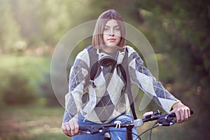 Happy young positive student going to school by bike