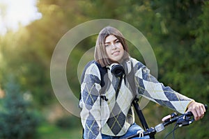 Happy young positive student going to school by bike