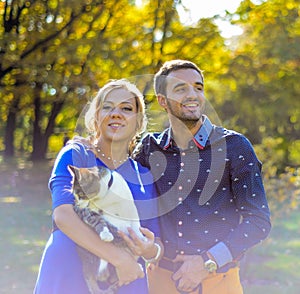 Happy and young pregnant couple hugging in nature