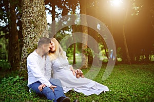 Happy and young pregnant couple hugging outdoor