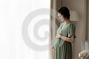 Happy young pregnant woman touch caress belly