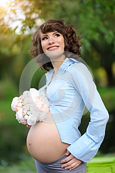 Happy young pregnant woman touching her belly