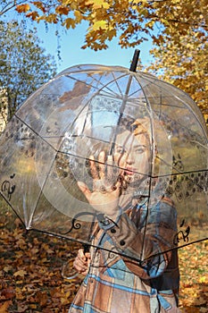 A happy young pregnant woman with an umbrella is waiting for her baby