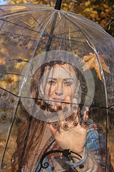 A happy young pregnant woman with an umbrella is waiting for her baby