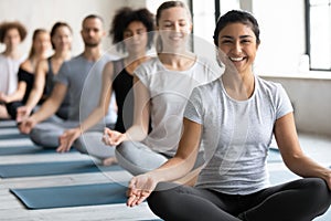 Happy young pretty indian ethnicity woman sitting in lotus pose.