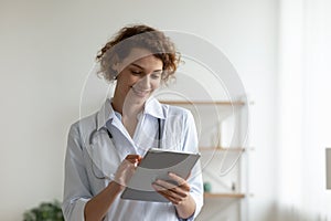 Happy young professional general practitioner using digital computer tablet.