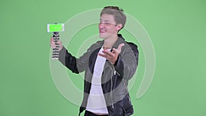 Happy young rebellious man vlogging and showing phone