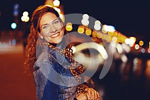 Happy young redhead woman smiling on Margaret Bridge at night Budapest
