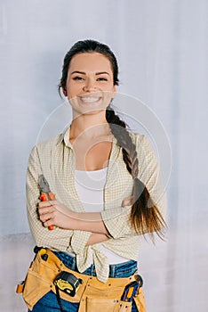 happy young repairwoman with pliers looking