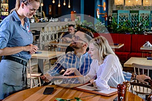 Young romantic couple ordering dinner together in a restaurant.