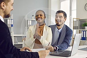 Happy young satisfied mixed ethnicity couple thanks bank manager broker