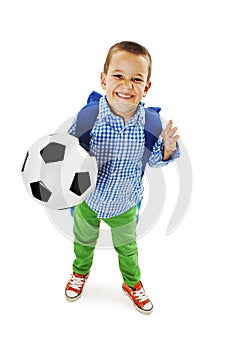 Happy young school boy holding a football
