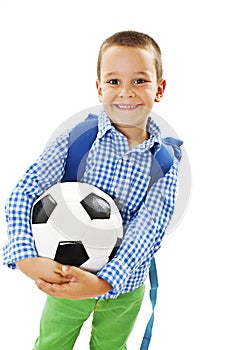 Happy young school boy holding a football