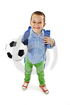 Happy young school boy holding a football