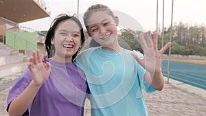 happy young school girls standing together smiling and looking at the camera