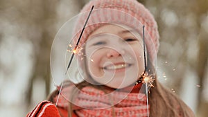 Feliz joven chica de escuela espumoso chispas de Bengala las luces Bosque sobre el víspera de nuevo anos 