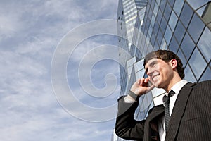 Happy young scuccessful businessman on phone