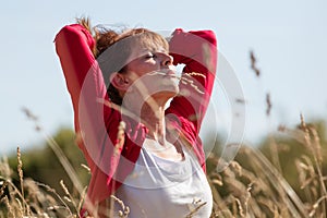 Happy young senior woman in harmony with nature