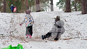 happy young sister girl kid pulling sled sledding slide laughing little brother kids children running in snow cheerful