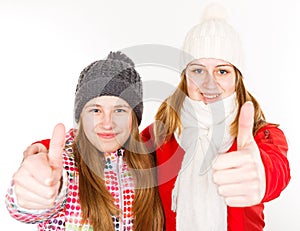 Happy young sisters showing thumbs up