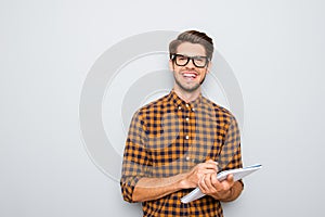 Happy young smart student in glasses writing in notebook